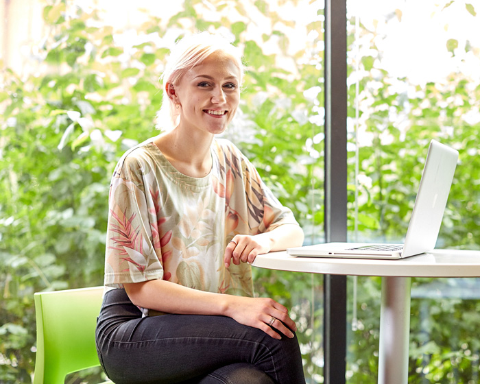 A student sat with a laptop