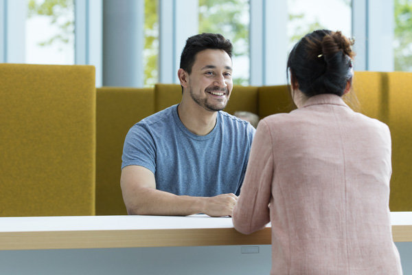 A student chatting with a member of staff across a table