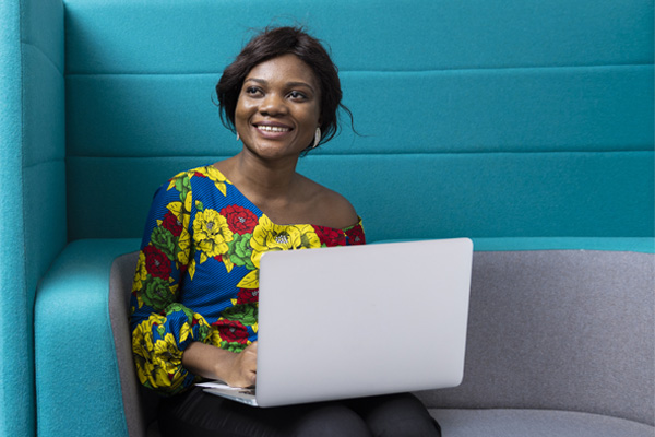 A student sat working on a laptop in a study space on campus