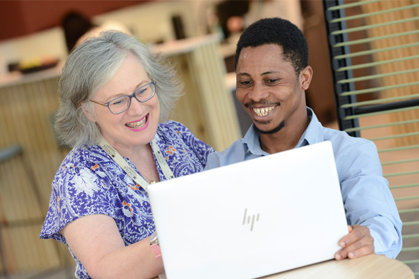 Two people looking at a laptop