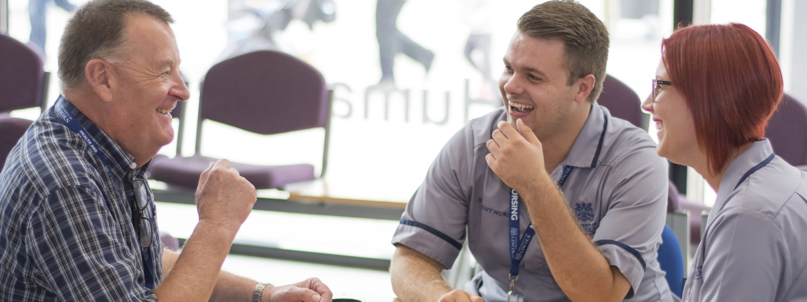 two nurses talking to a man