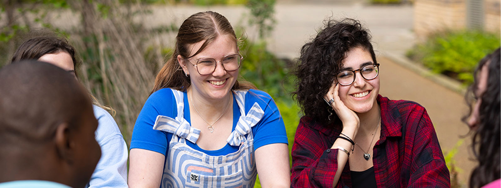 Two female students sat next to each other smiling